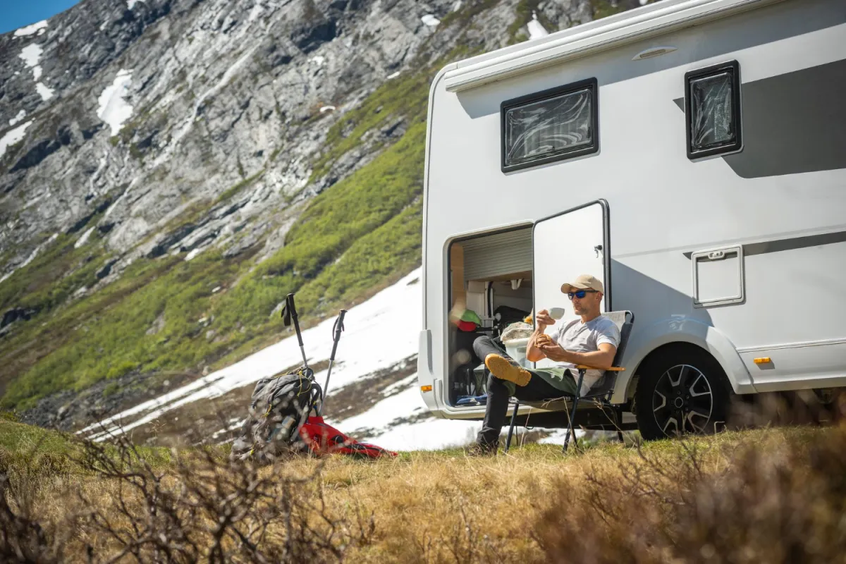 Toerist voor zijn camper neemt een korte pauze